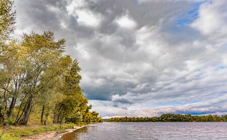 Heavy clouds in the sky over the Dnieper river announce the incoming of a stormの写真素材