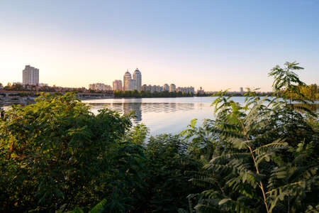 High Obolon buildings near the Dnieper river in Kiev, Ukraine. Blue clear sky and reflection in the...
