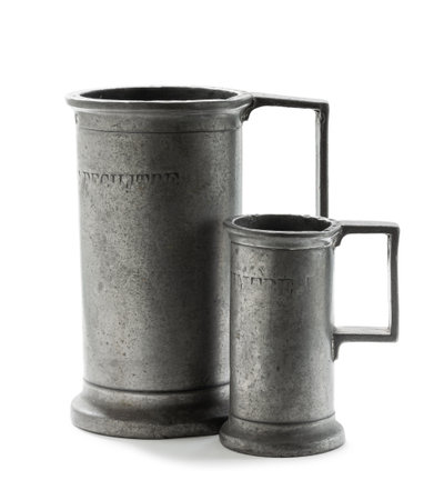 A pair of antique pewter capacity measures isolated on white backgroundの写真素材