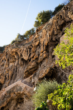 Detail of the cliff over Cotignac, a French village in the Var department of the Provence-Alpes-CÃ´te d'Azur region. It is famous for its troglodyte dwellings that are carved into tufa cliffs covered with large stalactites, and its two feudal towers from 1033.の写真素材