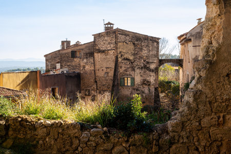 View of an old house in Cotignac, a French village in the Var department of the Provence-Alpes-CÃ´te d'Azur region. It is famous for its troglodyte dwellings that are carved into tufa cliffs covered with large stalactites, and its two feudal towers from 1033.の写真素材