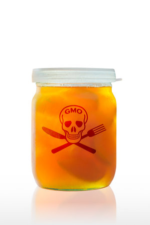 A closed glass jar of GMO food on a white background, with reflection on the tableの写真素材