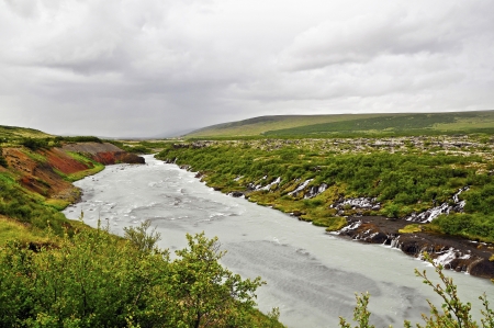 Hraunfossar is a sequence of waterfalls formed by small streams over a length of more than 900 metersの写真素材