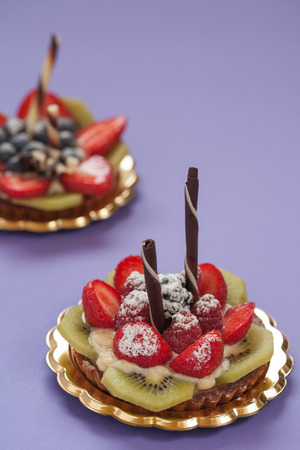 Italian pastry with strawberries blackberries kiwi raspberry cream and chocolateの写真素材