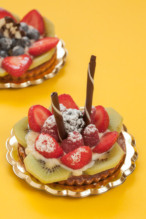 Italian pastry with strawberries blackberries kiwi raspberry cream and chocolateの写真素材
