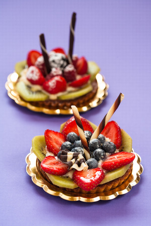 Italian pastry with strawberries blackberries kiwi raspberry cream and chocolateの写真素材