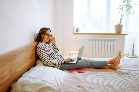 Young female freelancer works and makes notes while working at home in quarantine lockdown. freelancer.の写真素材