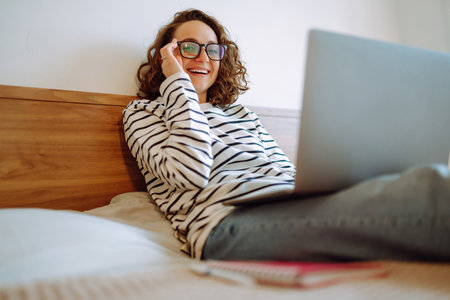 Young female freelancer works and makes notes while working at home in quarantine lockdown. freelancer.の写真素材