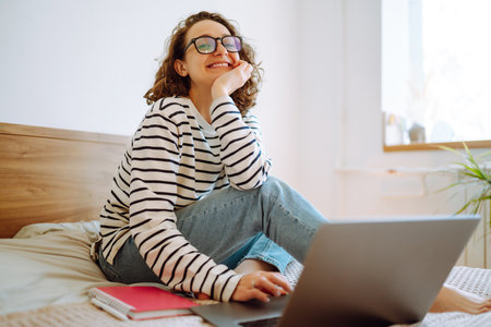 Young female freelancer works and makes notes while working at home in quarantine lockdown. freelancer.の写真素材
