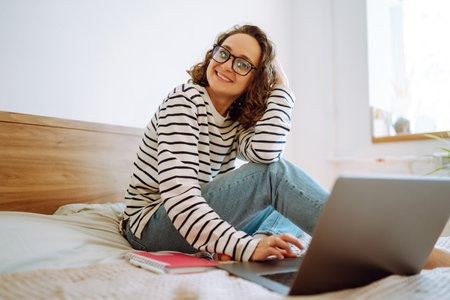 Young female freelancer works and makes notes while working at home in quarantine lockdown. freelancer.の写真素材