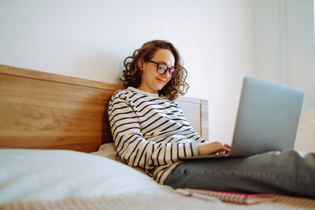 Young female freelancer works and makes notes while working at home in quarantine lockdown. freelancer.の写真素材