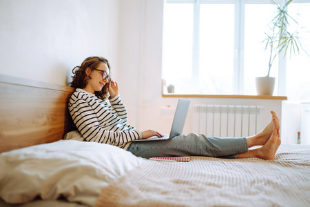 Young female freelancer works and makes notes while working at home in quarantine lockdown. freelancer.の写真素材