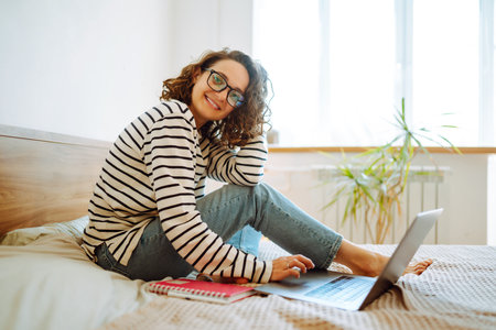 Young female freelancer works and makes notes while working at home in quarantine lockdown. freelancer.の写真素材