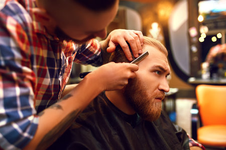Time for a new hairdo. Handsome young bearded man came to the barber for a haircut. hipster style.の写真素材