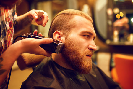 Time for a new hairdo. Handsome young bearded man came to the barber for a haircut. hipster style.の写真素材