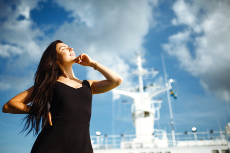 Smiling girl on a ferry. Young woman sitts on the deck of the ferry boat on summer vacation.の写真素材