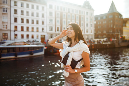 Beautiful stylish girl walks in the city of Norway on a sunny day. Young women enjoy.の写真素材