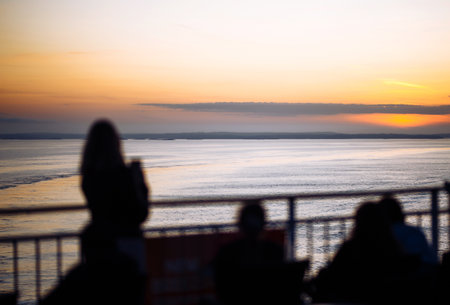 Beautiful sunset on a ship. Silhouette of a young woman enjoying sunset. Traveling, nature concept.