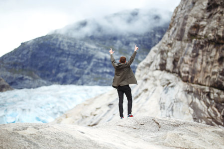 Young man posing on a background of mountains in the Norway. Man tourist hiking to beautiful...