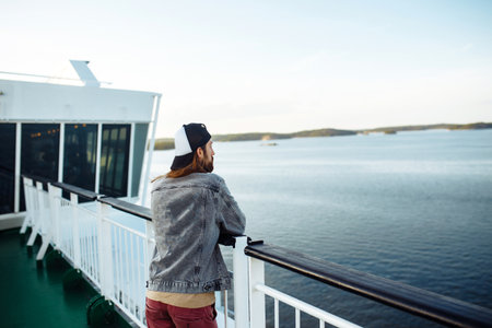 Guy enjoys a ferry ride or ship, sailing to the island tourist destination on summer vacation in...