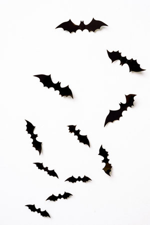 halloween and decoration concept - black 3d paper bats flying over white background.の写真素材