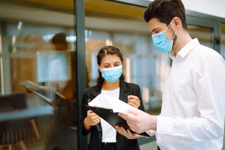 Two manager in protective face masks having an argument discussing business Issue. Covid-19.の写真素材