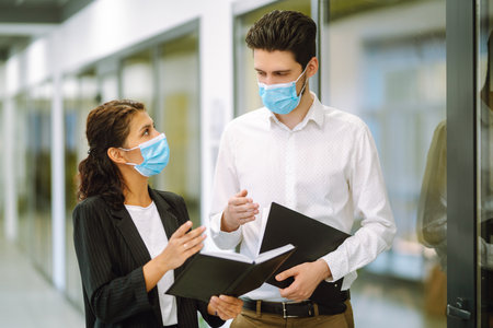 Two manager in protective face masks having an argument discussing business Issue. Covid-19.