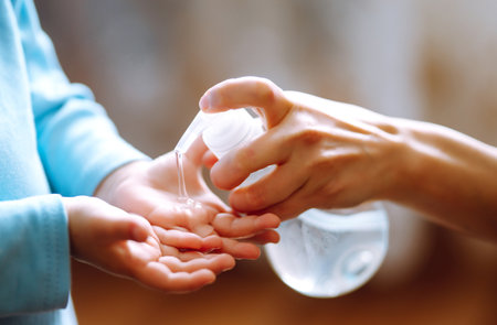 Hands with sanitizer gel. Mother and child using sanitize soap for hand coronavirus protection.の写真素材