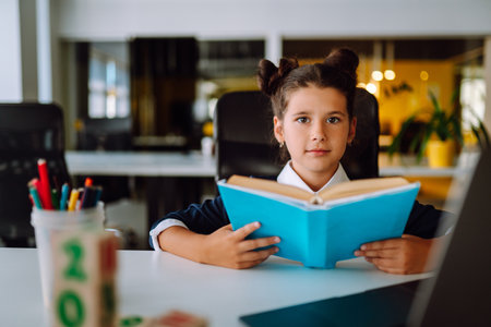 School girl in medical mask using laptop computer studying through online e-learning system.