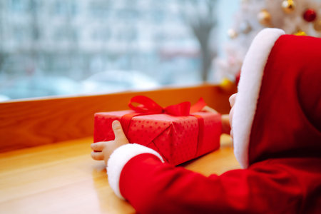 Little boy in santa costume open a christmas gift. Winter holiday, New Year.の写真素材