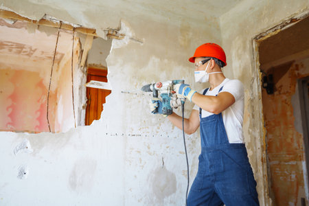 Repairer in boilersuit holding tools. Apartment repair and renovation concept. building.の写真素材