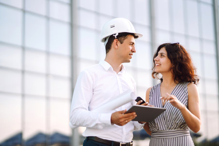 Two workers in a helmet at a work object discuss working issues.の写真素材