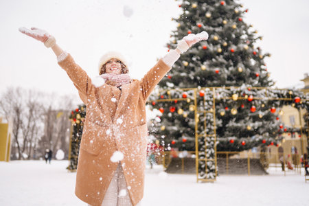 Young woman in winter style clothes posing at festive street market. cold weather. Winter fashion, holidays.の写真素材