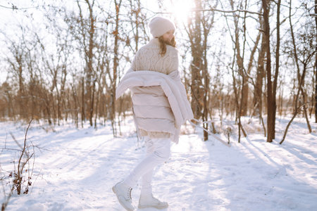 Happy woman in winter style clothes walking in the snowy park. Nature, holidays, travel concept.の写真素材