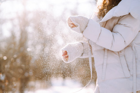 Young woman in winter style clothes walking in the snowy park. Winter fashion, holidays.の写真素材