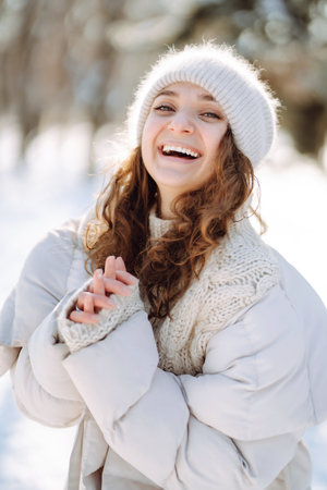 Young woman in winter style clothes walking in the snowy park. Winter fashion, holidays.の写真素材