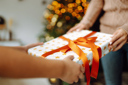 Gives the gift. Changing the christmas presen. Young woman gives a gift in a box. winter holiday.の写真素材