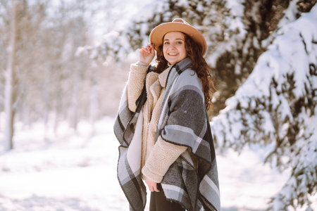 Pretty Woman holding a giftbox with red ribbon in the winter park. Happy winter time. new year's.の写真素材
