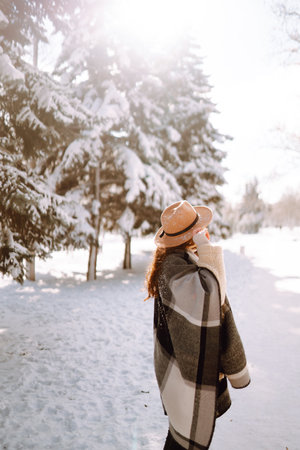 Pretty Woman holding a giftbox with red ribbon in the winter park. Happy winter time. new year's.の写真素材