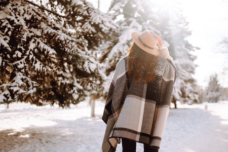 Pretty Woman holding a giftbox with red ribbon in the winter park. Happy winter time. new year's.の写真素材