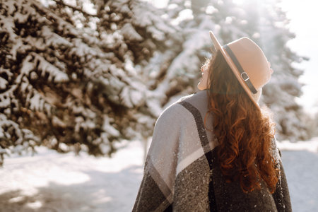 Beautiful woman standing among snowy trees and enjoying first snow. Happy winter time. Christmas.の写真素材