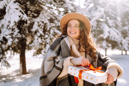 Beautiful woman standing among snowy trees and enjoying first snow. Happy winter time. Christmas.の写真素材