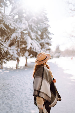 Beautiful woman standing among snowy trees and enjoying first snow. Happy winter time. Christmas.の写真素材