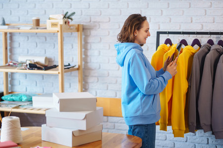Small business owner, entrepreneur, seller using tablet checking ecommerce clothing store orders.の写真素材