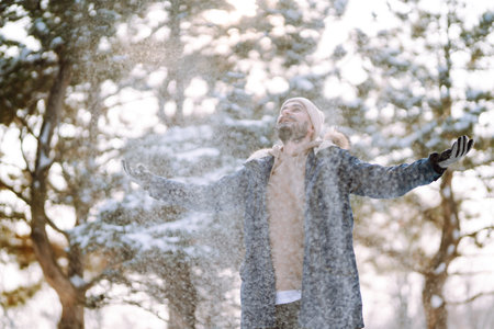 Portrait of young man in snowy winter forest. Season, christmas, travel and people concept.の写真素材