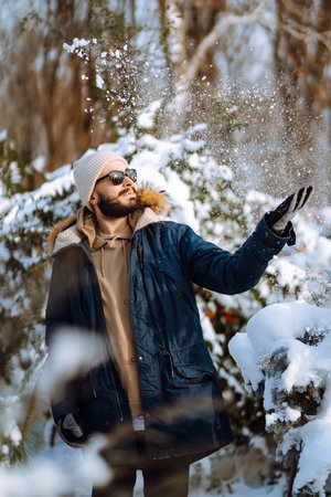 Portrait of young man in snowy winter forest. Season, christmas, travel and people concept.の写真素材