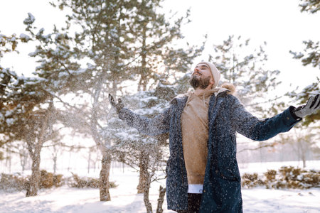 Portrait of young man in snowy winter forest. Season, christmas, travel and people concept.の写真素材