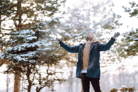 Portrait of young man in snowy winter forest. Season, christmas, travel and people concept.の写真素材