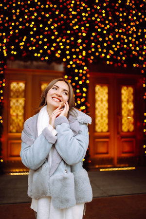 Young woman ice skating on the ice arena in the city square in winter on Christmas Eve. winter holiday.の写真素材