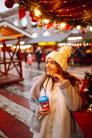 Young woman ice skating on the ice arena in the city square in winter on Christmas Eve. winter holiday.の写真素材